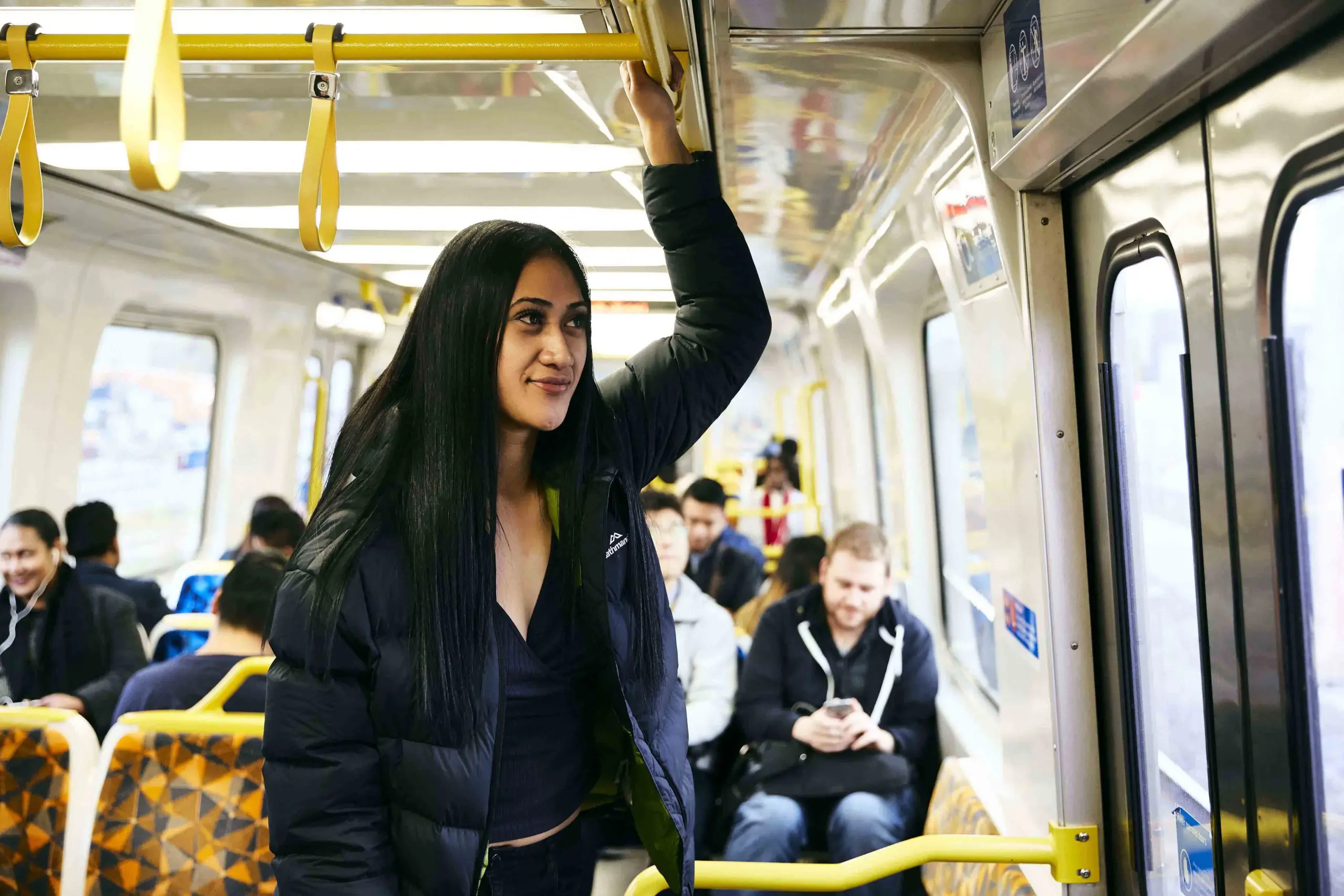 A young woman travelling on a metro train.